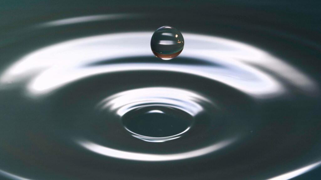 A sense of calm represented by a single drop bouncing off a body of water, forming concentric circles.