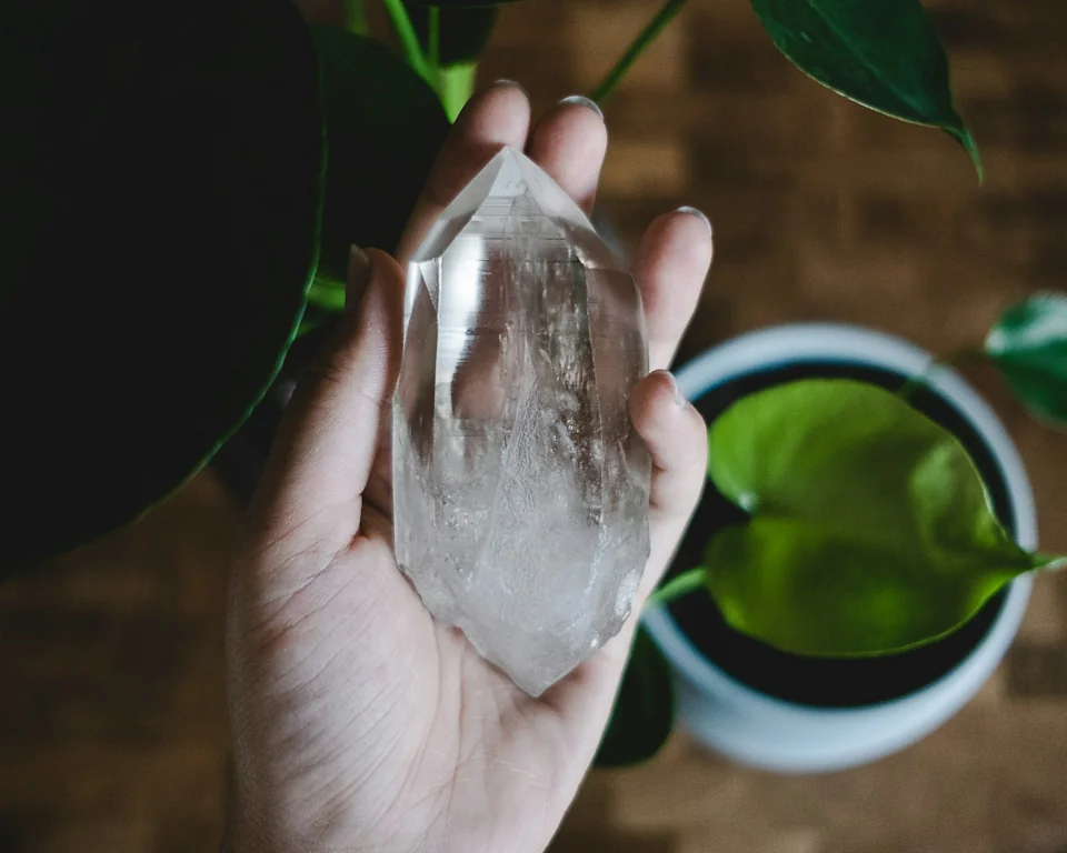 Hand holding a double terminated quartz crystal.