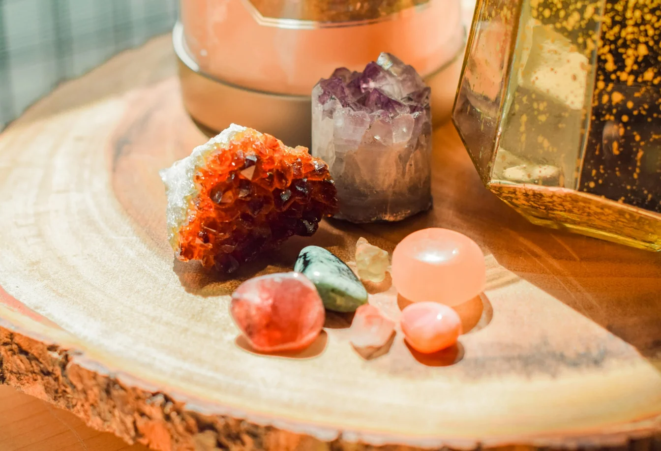 A variety of crystals on a wooden table.