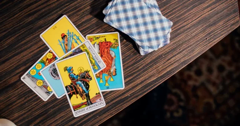 A calm, grounded scene with a few tarot cards face-up on a dark wooden table